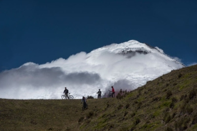 Cotopaxi Volcano in the background with the silouette of bikers in front